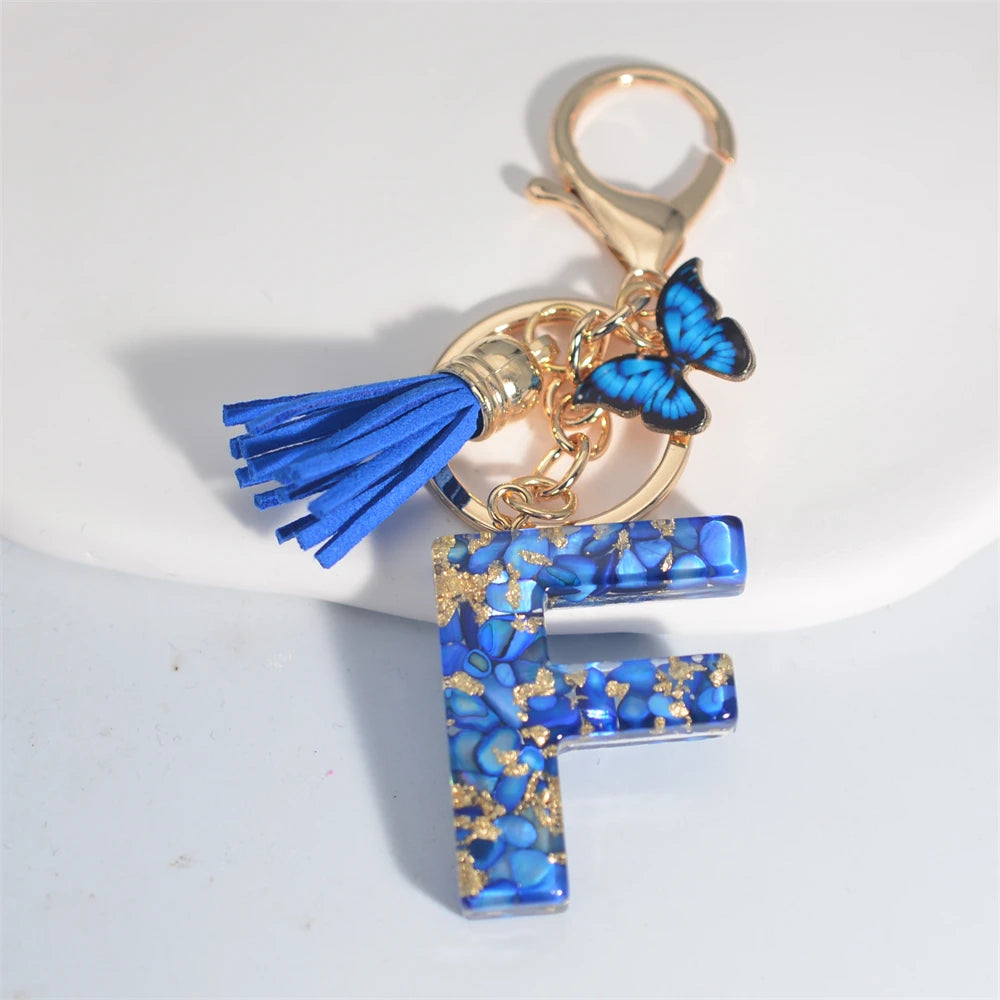 Exquisito llavero de resina de piedra esmaltada azul de A a Z, 26 iniciales, colgante de borla de mariposa, llavero para mujeres y hombres, llavero de coche, regalo