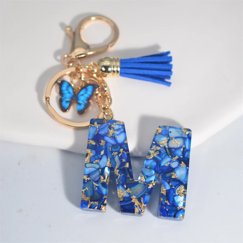 Exquisito llavero de resina de piedra esmaltada azul de A a Z, 26 iniciales, colgante de borla de mariposa, llavero para mujeres y hombres, llavero de coche, regalo