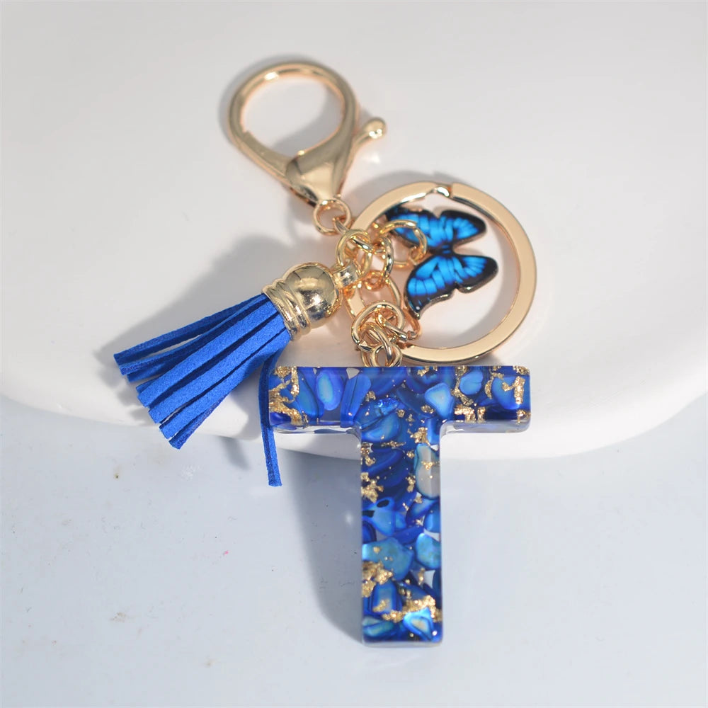 Exquisito llavero de resina de piedra esmaltada azul de A a Z, 26 iniciales, colgante de borla de mariposa, llavero para mujeres y hombres, llavero de coche, regalo