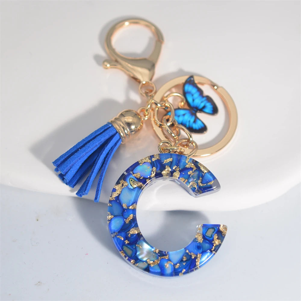 Exquisito llavero de resina de piedra esmaltada azul de A a Z, 26 iniciales, colgante de borla de mariposa, llavero para mujeres y hombres, llavero de coche, regalo