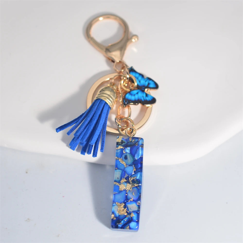 Exquisito llavero de resina de piedra esmaltada azul de A a Z, 26 iniciales, colgante de borla de mariposa, llavero para mujeres y hombres, llavero de coche, regalo