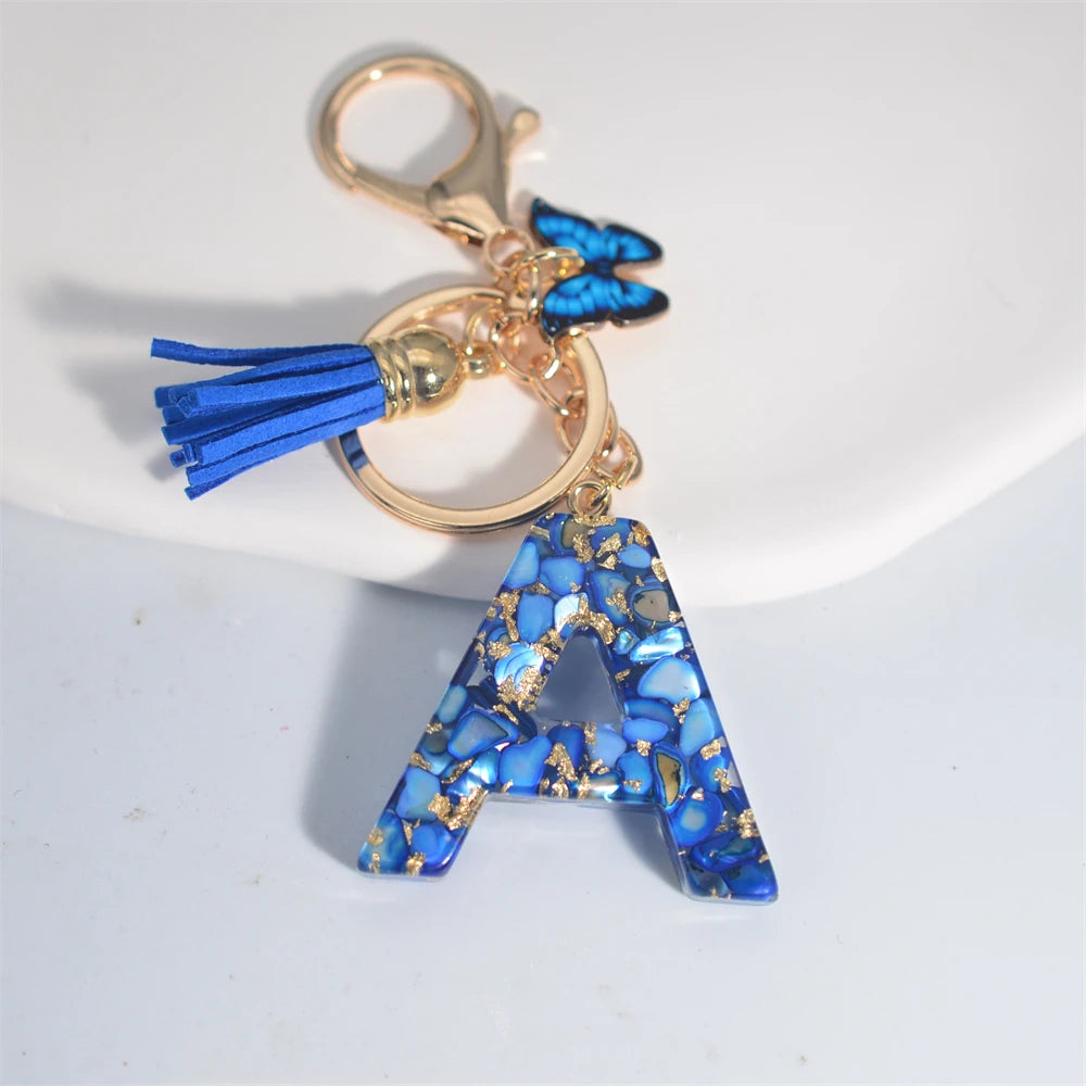 Exquisito llavero de resina de piedra esmaltada azul de A a Z, 26 iniciales, colgante de borla de mariposa, llavero para mujeres y hombres, llavero de coche, regalo
