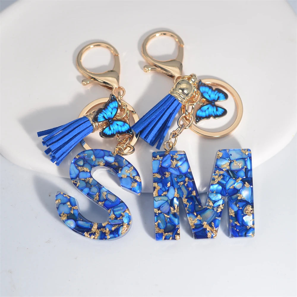 Exquisito llavero de resina de piedra esmaltada azul de A a Z, 26 iniciales, colgante de borla de mariposa, llavero para mujeres y hombres, llavero de coche, regalo