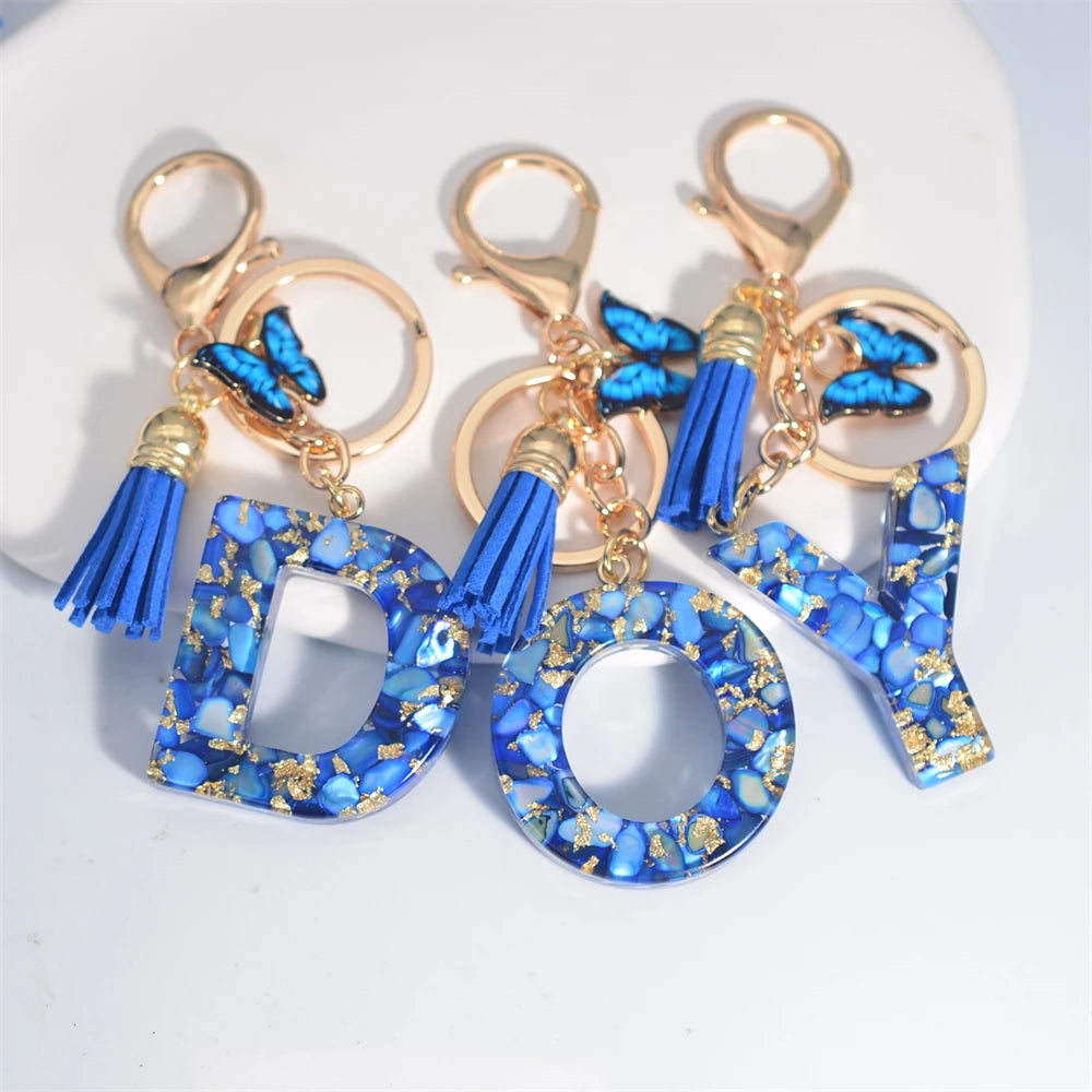 Exquisito llavero de resina de piedra esmaltada azul de A a Z, 26 iniciales, colgante de borla de mariposa, llavero para mujeres y hombres, llavero de coche, regalo