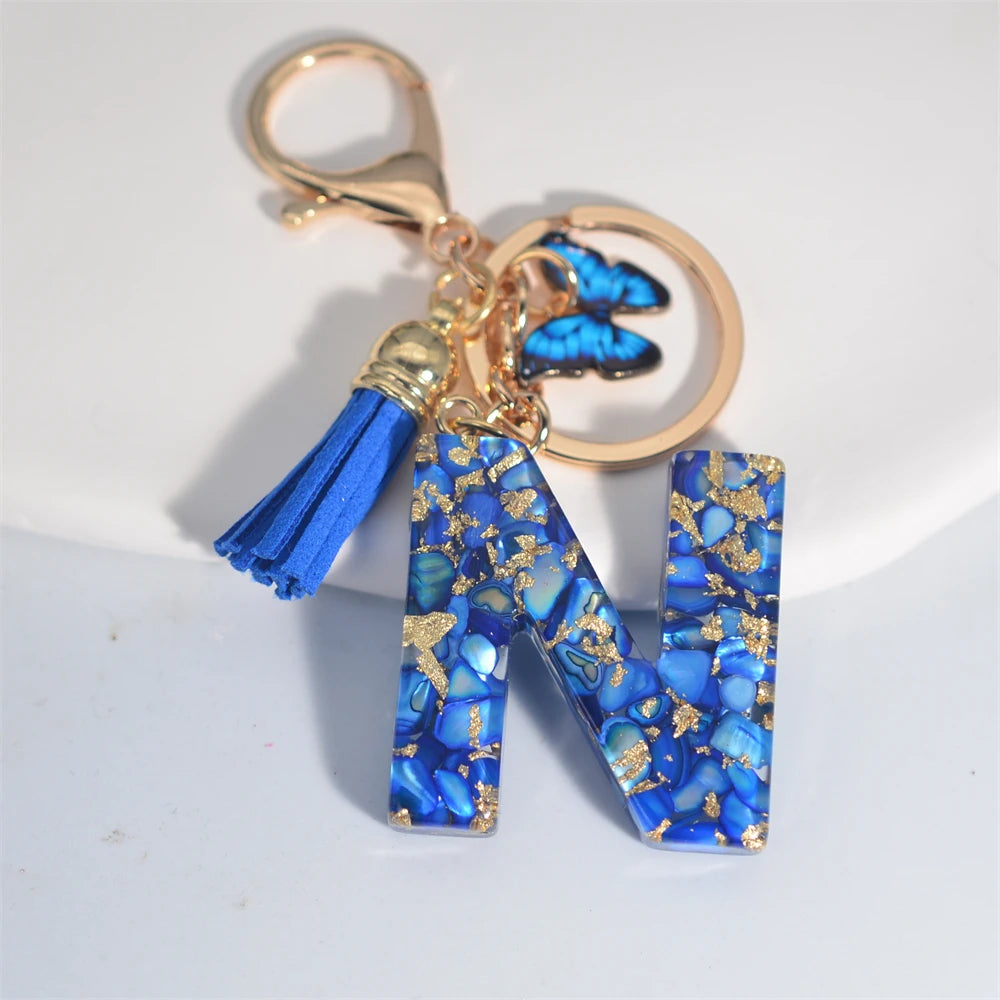 Exquisito llavero de resina de piedra esmaltada azul de A a Z, 26 iniciales, colgante de borla de mariposa, llavero para mujeres y hombres, llavero de coche, regalo