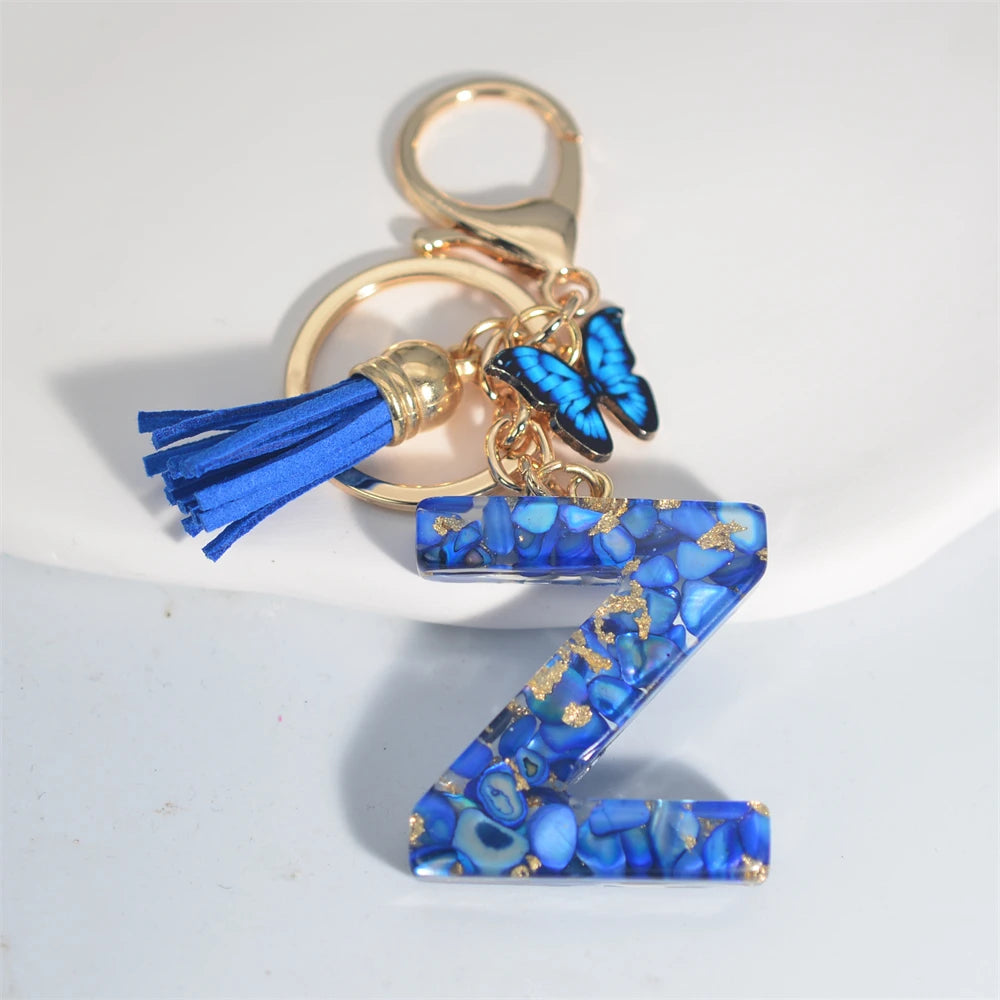 Exquisito llavero de resina de piedra esmaltada azul de A a Z, 26 iniciales, colgante de borla de mariposa, llavero para mujeres y hombres, llavero de coche, regalo