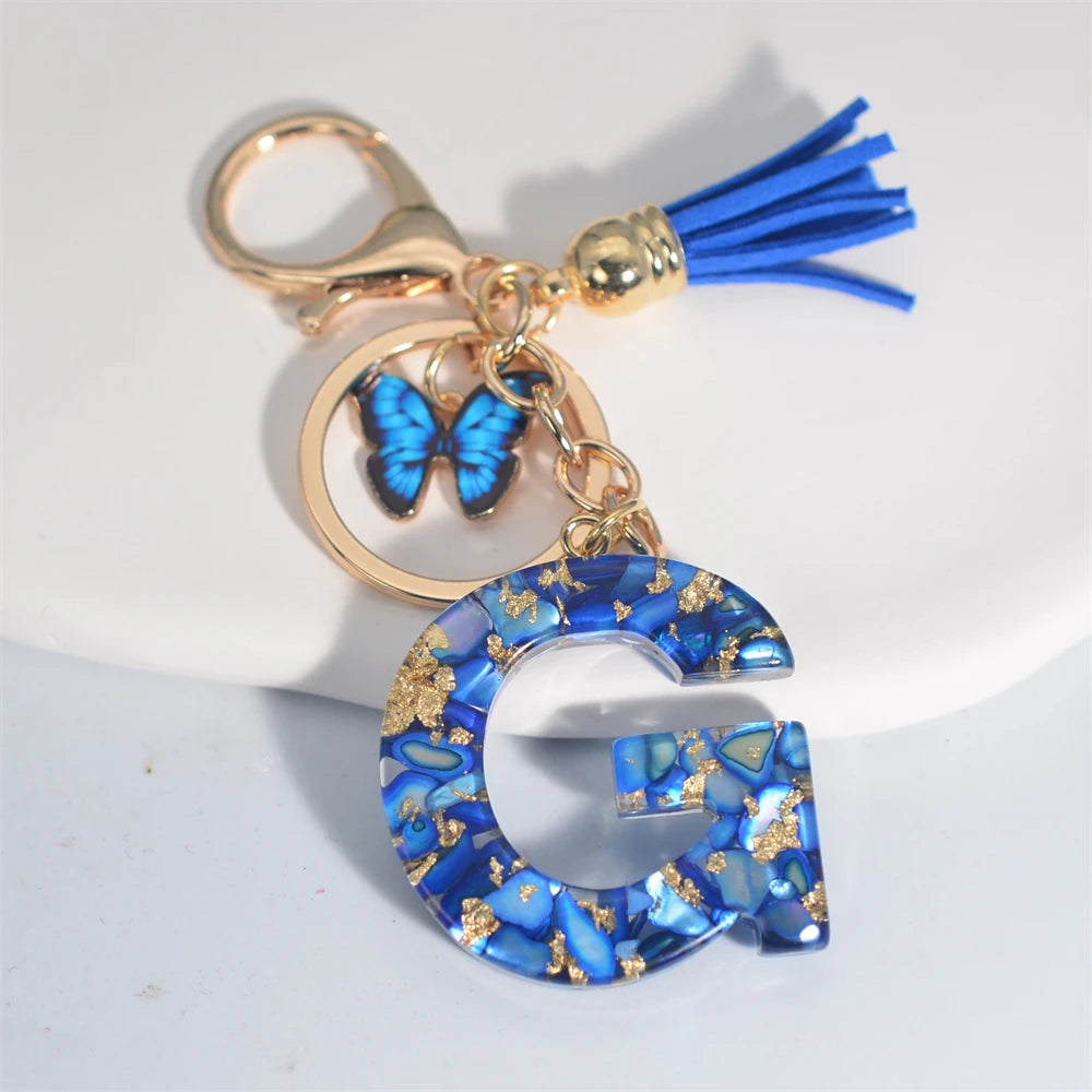 Exquisito llavero de resina de piedra esmaltada azul de A a Z, 26 iniciales, colgante de borla de mariposa, llavero para mujeres y hombres, llavero de coche, regalo