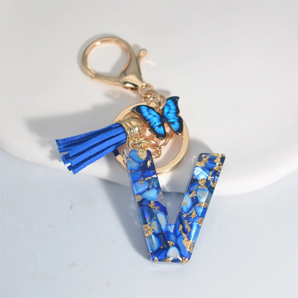 Exquisito llavero de resina de piedra esmaltada azul de A a Z, 26 iniciales, colgante de borla de mariposa, llavero para mujeres y hombres, llavero de coche, regalo