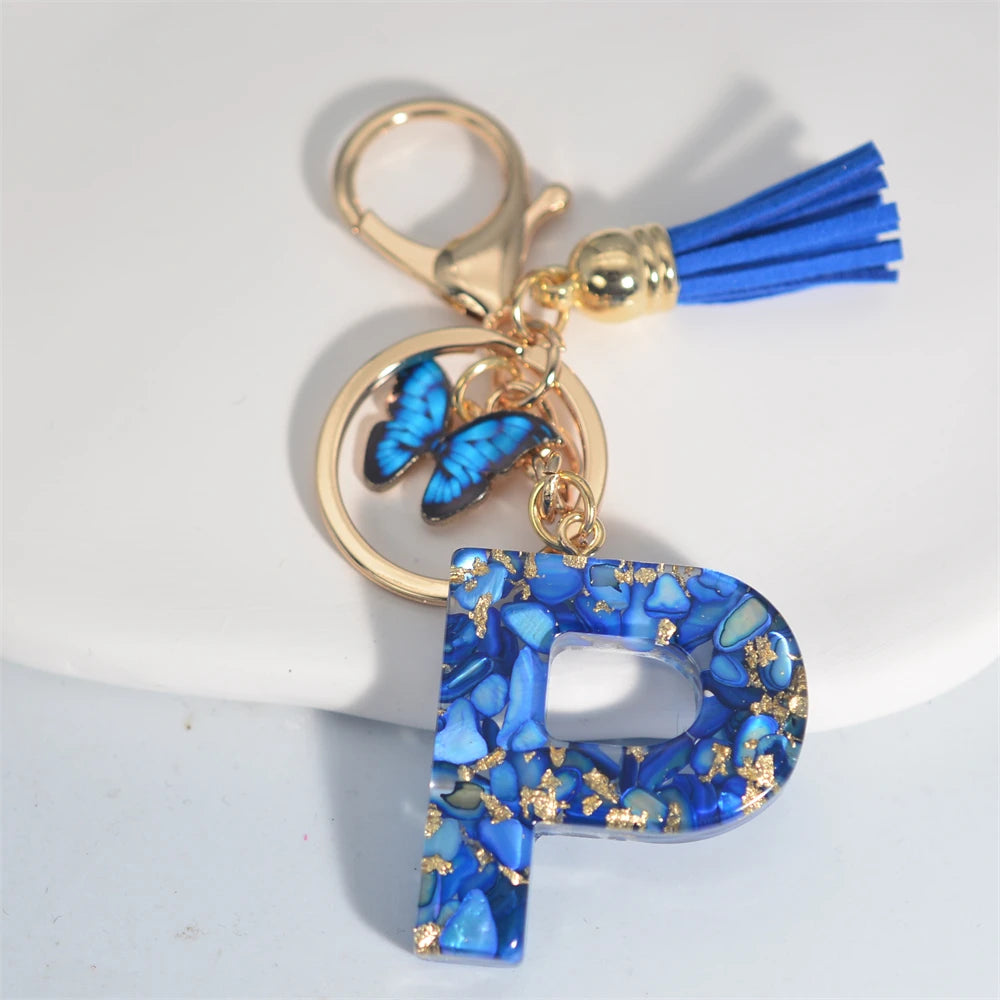 Exquisito llavero de resina de piedra esmaltada azul de A a Z, 26 iniciales, colgante de borla de mariposa, llavero para mujeres y hombres, llavero de coche, regalo