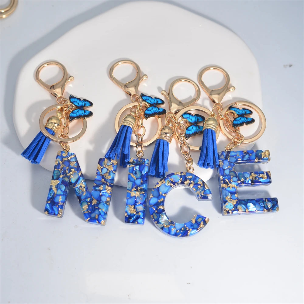 Exquisito llavero de resina de piedra esmaltada azul de A a Z, 26 iniciales, colgante de borla de mariposa, llavero para mujeres y hombres, llavero de coche, regalo
