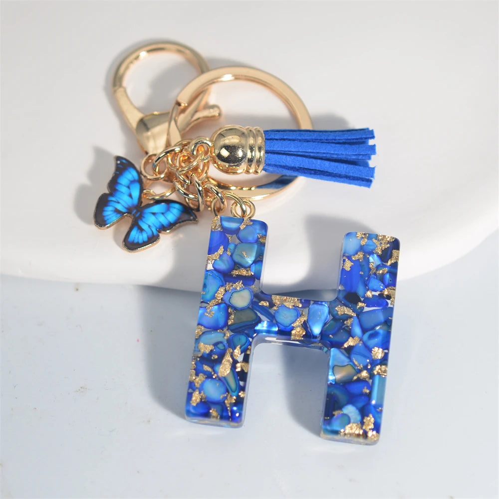 Exquisito llavero de resina de piedra esmaltada azul de A a Z, 26 iniciales, colgante de borla de mariposa, llavero para mujeres y hombres, llavero de coche, regalo